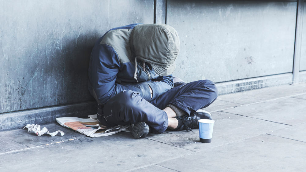 Young homeless man bundled up