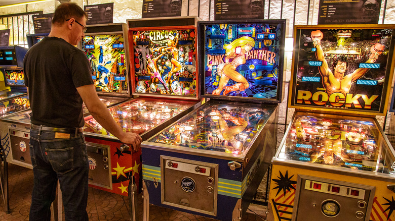 man playing pinball machine