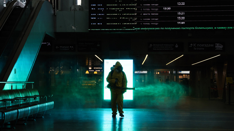 person spraying Russian train station with disinfectant