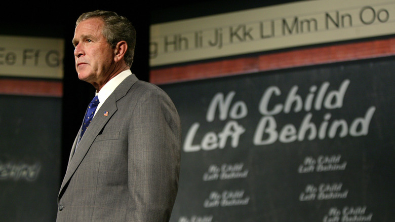 George W. Bush standing in front of a blackboard