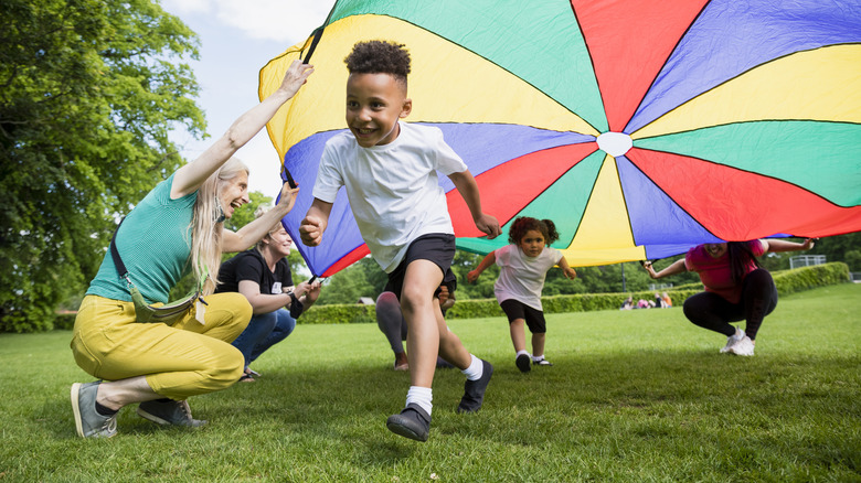 children running under a parachute