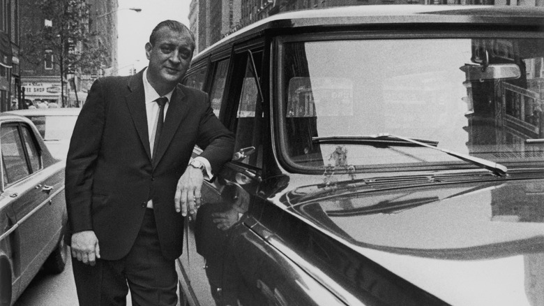 Rodney Dangerfield posing with a car