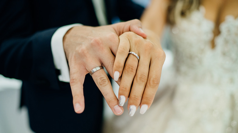 couple holding wedding rings