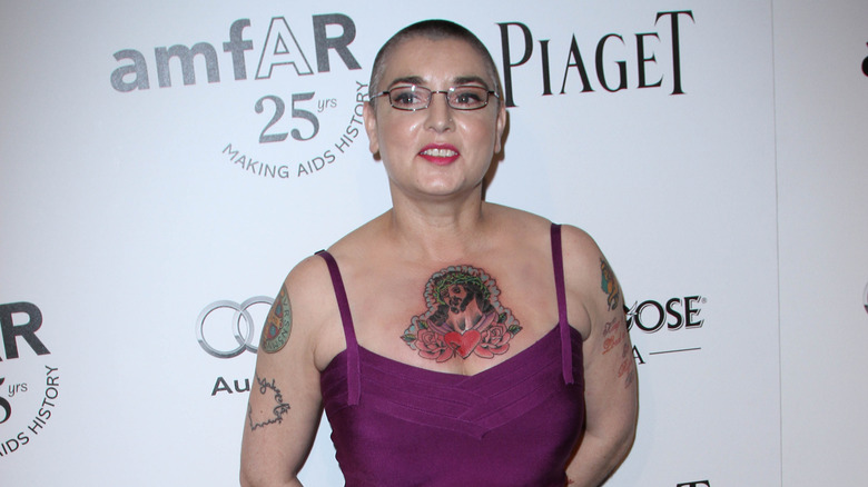 Sinéad O'Connor in pink dress and glasses