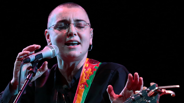 Sinéad O'Connor with mic guitar and rainbow strap