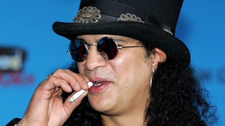Slash with a cigarette in his hand