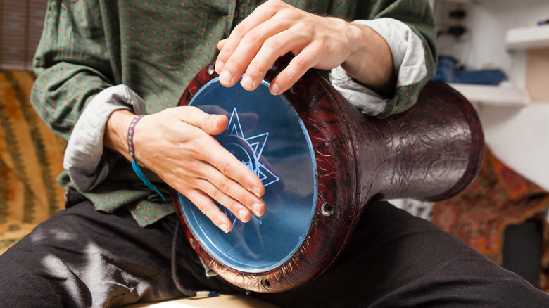 Man's hands playing a darbuka