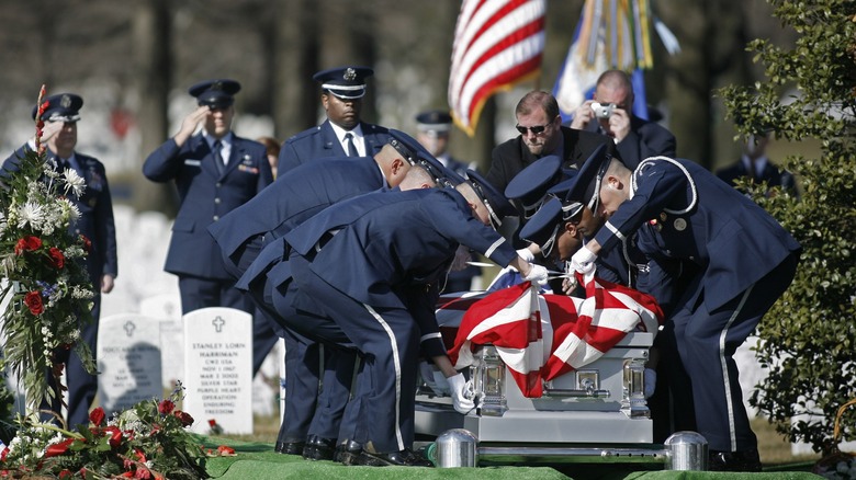 Airmen lowering casket into ground