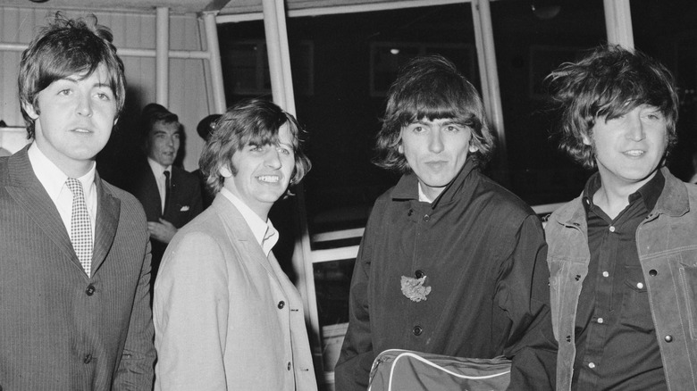 The Beatles posing for photographers at an airport