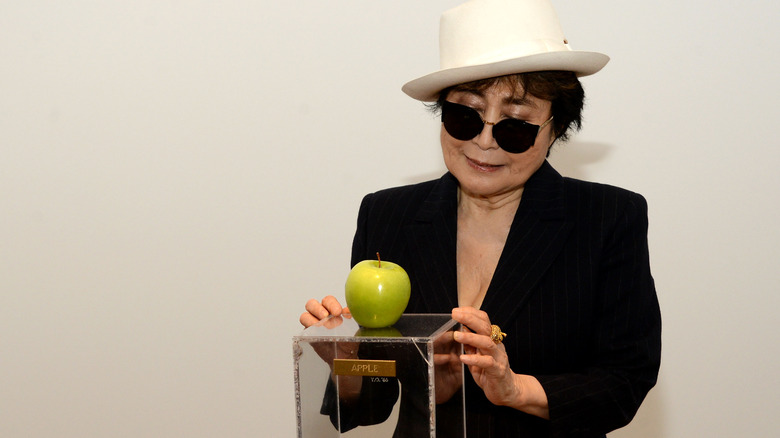 yoko ono looks at an apple