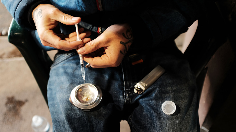 a drug user prepares a dose of heroin