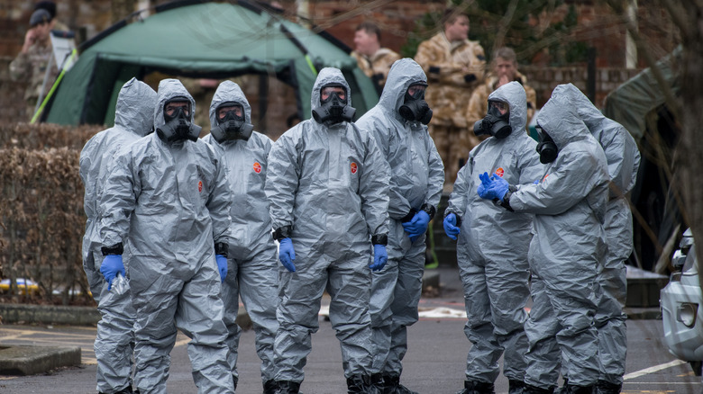 Military people in hazmat suits