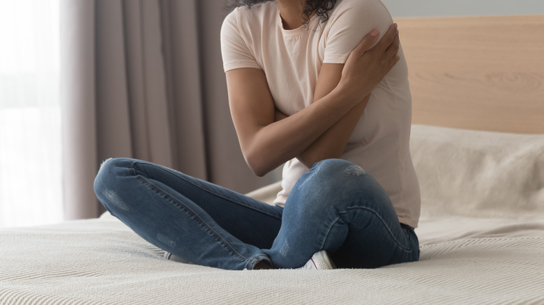 Black woman sitting on bed