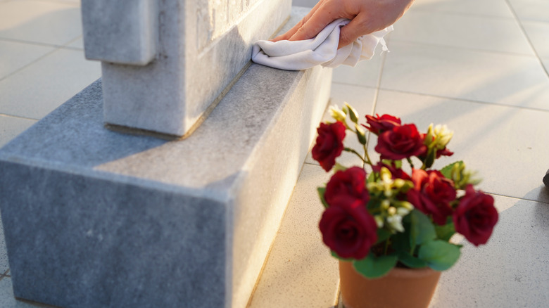 A woman cleans a grave