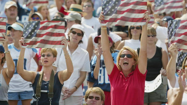 A halftime crowd holds up American flag cards during Toby Keith's performance