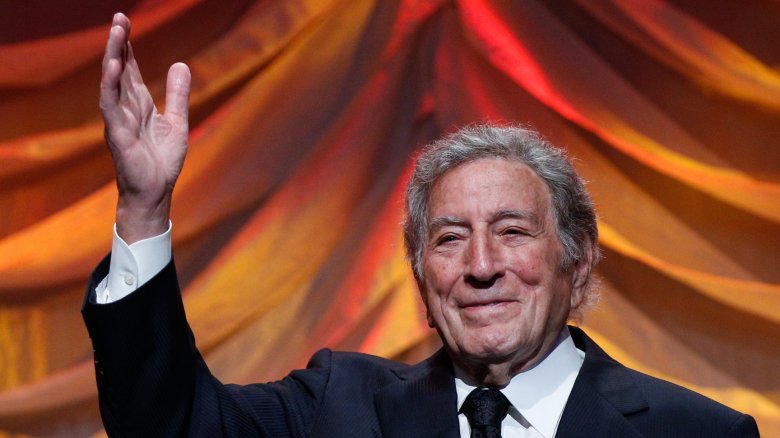 Tony Bennett waving in front of a curtain