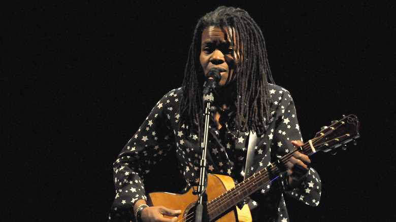 Tracy Chapman on stage with guitar and mic