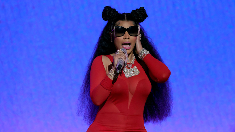 Nicky Minaj performing in sunglasses with silver mic