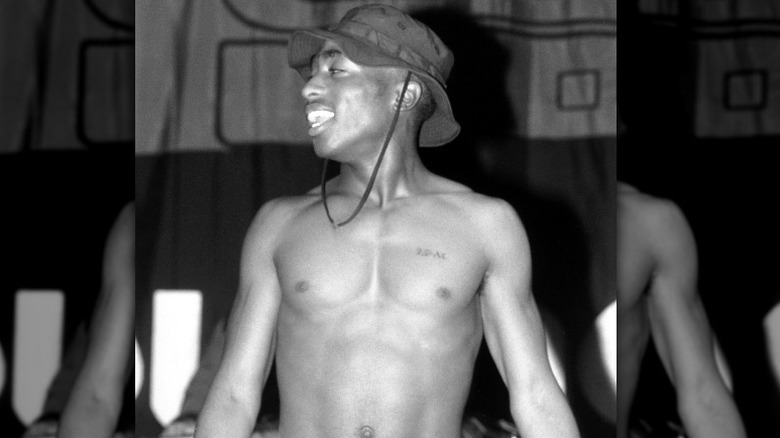 Tupac Shakur wearing hat onstage