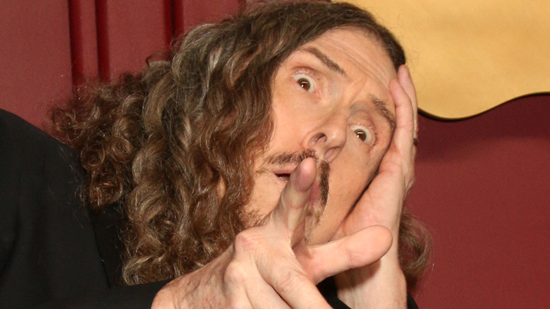 Weird Al Yankovic pretended to be horrified and points at a camera.