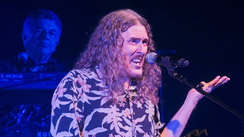 Weird Al Yankovic talks onstage in 2023.