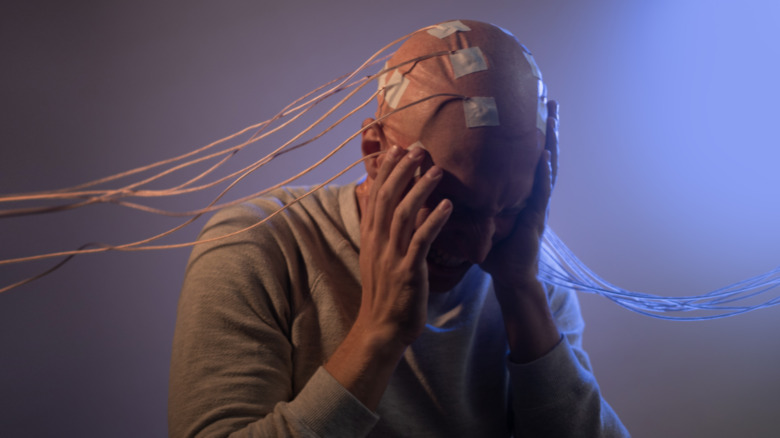 Man with wired-up brain sitting