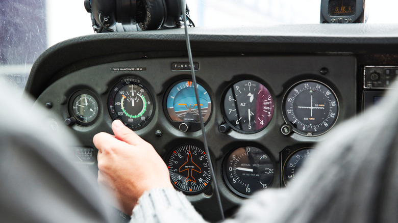 man tinkering with Cessna control board