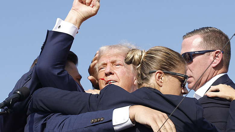 Bleeding Trump kneeling on stage