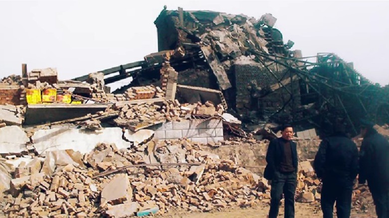 men standing around rubble