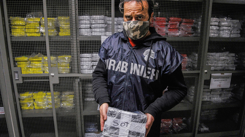 an Italian policeman with seized cocaine