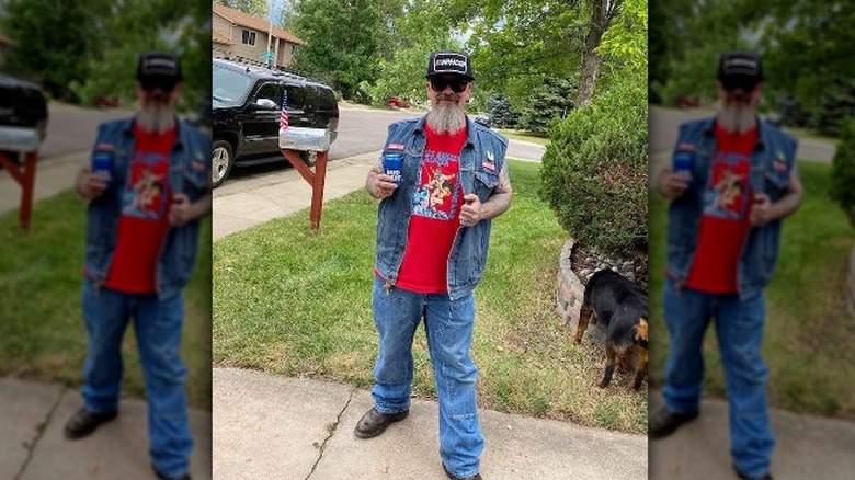 William Henderson black cap beard denim standing outside