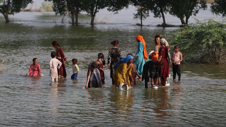 group of people walking through flood