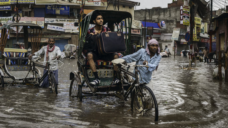 man biking through flood water