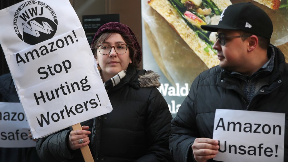 protesting Amazon workers hold signs