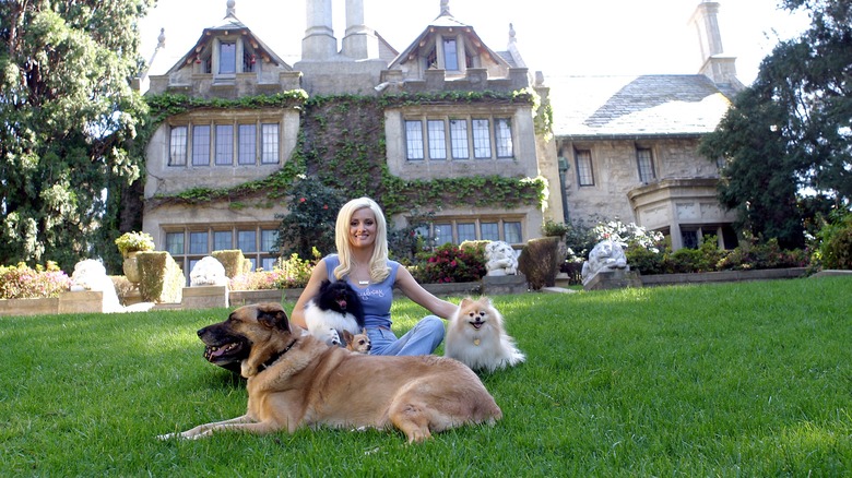 Holy Madison posing with dogs in front of the Playboy Mansion