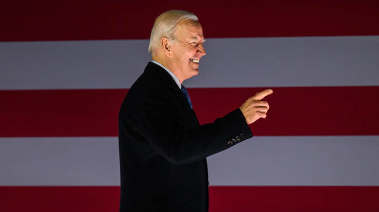 Joe Biden pointing and smiling with American flag