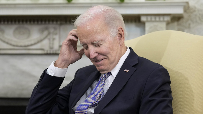 Joe Biden scratching his head and laughing