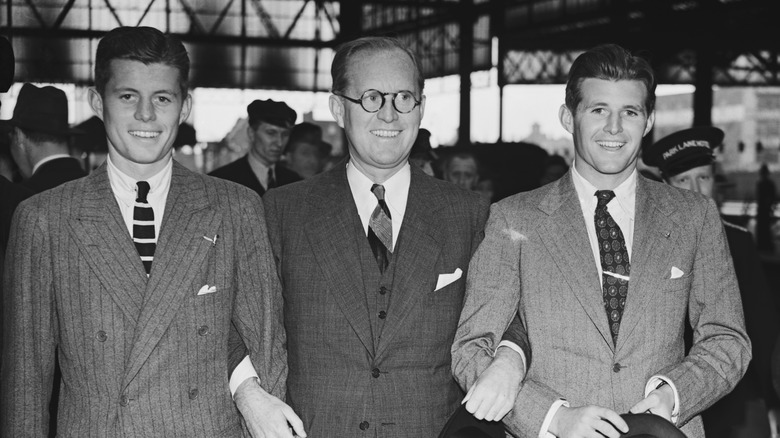 Joseph Kennedy links arms with sons