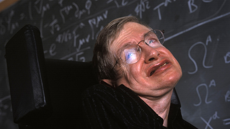 Stephen Hawking in front of chalkboard covered with equations