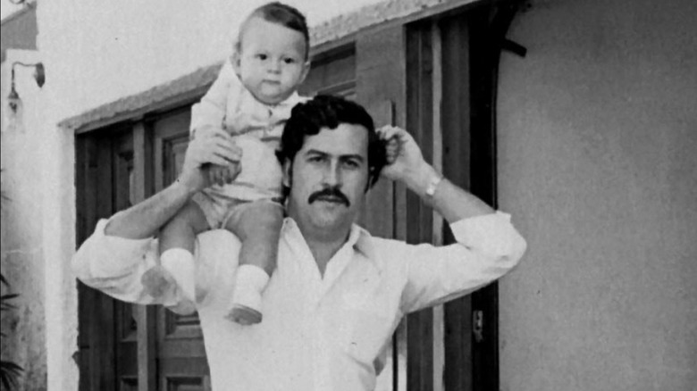 Pablo Escobar with baby on shoulder