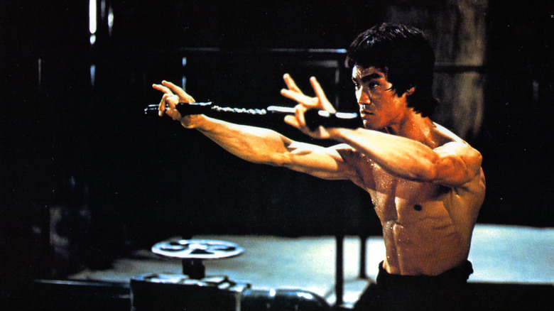 Bruce Lee shirtless with nunchucks 