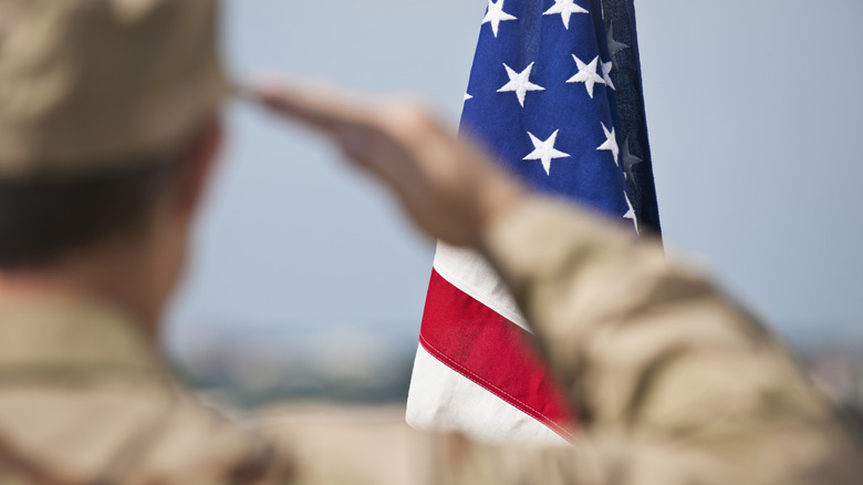 A soldier in uniform saluting the American flag