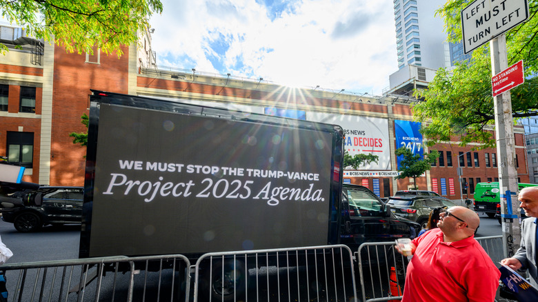 A bilboard that reads "We Must Stop the Trump-Vance Project 2025 Agenda"