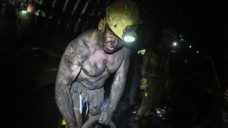 A coal miner covered in black dust