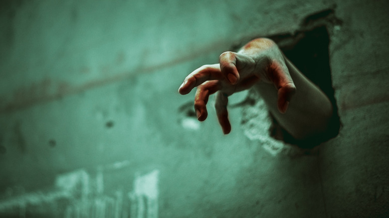 zombie hand reaching through a wall