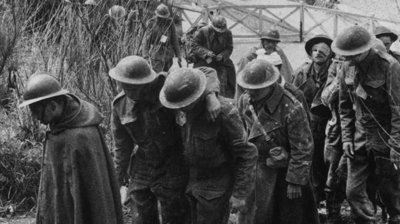 Allied POWs march through tall grass