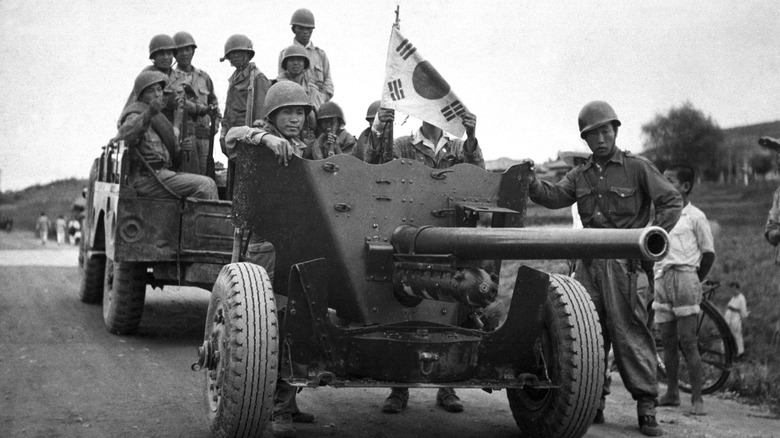 South Korean troops marching down road with artillery