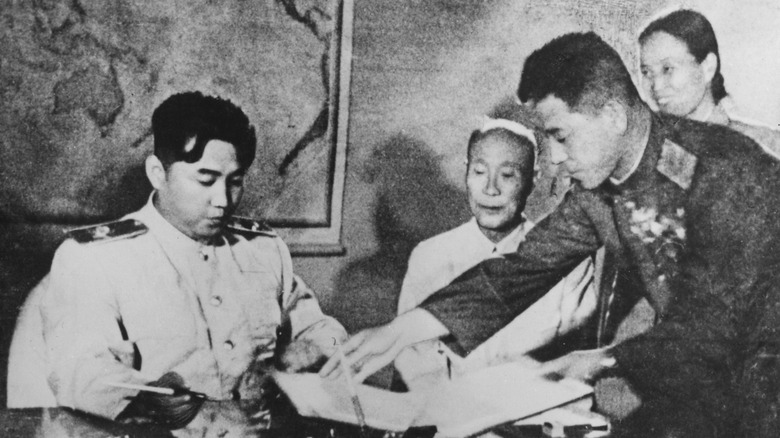 Kim Il Sung being handed the armistice in 1953