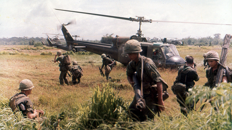 US troops in front of a helicopter during the Vietnam War