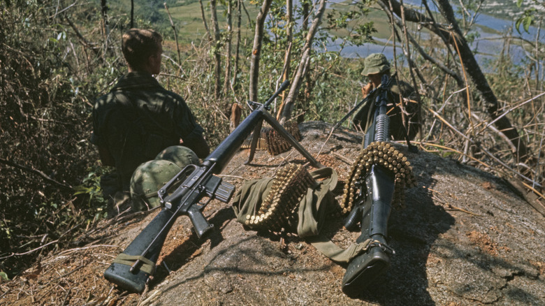 Mounted M16 and machine gun in front of troops in Vietnam